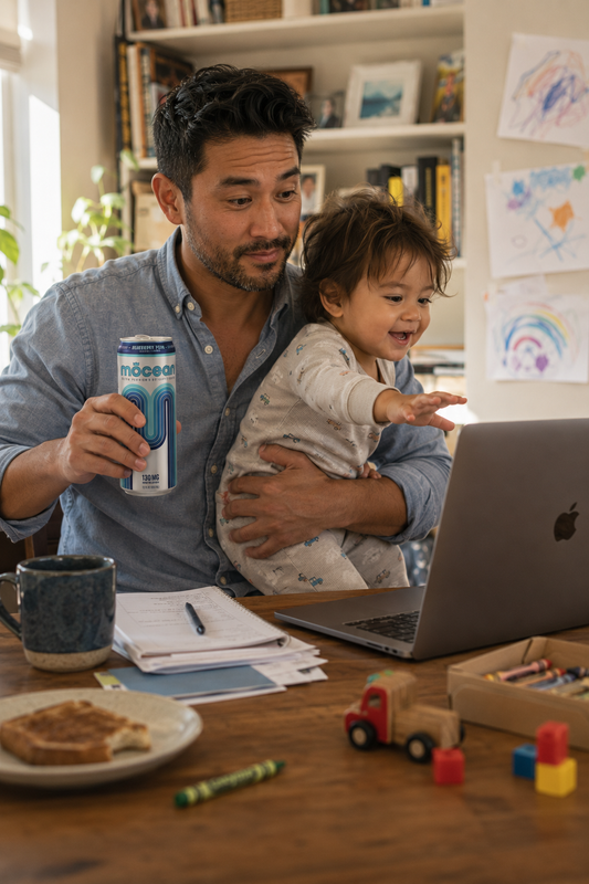 adult drinking a mōcean energy drink while working